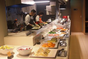 A buffet setup with various food items and serving utensils.