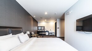 A modern hotel room with a large bed, a desk, a chair, and a television. - Gangneung Tourist Hotel (Gangneung)