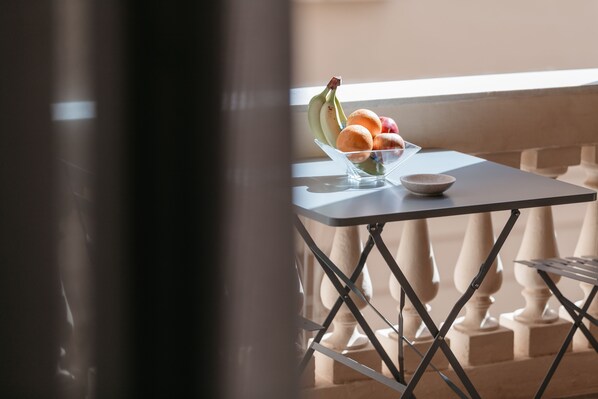 A clear view of a table with a fruit bowl containing bananas, oranges, and apples, and a small bowl on the table. - Euterpe L.H.T. (Agrigento)