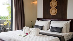 A neatly made bed with white linens and a welcome mat, a dark wooden headboard, and a wall-mounted woven basket. - Hotel Five.S (Kampot)