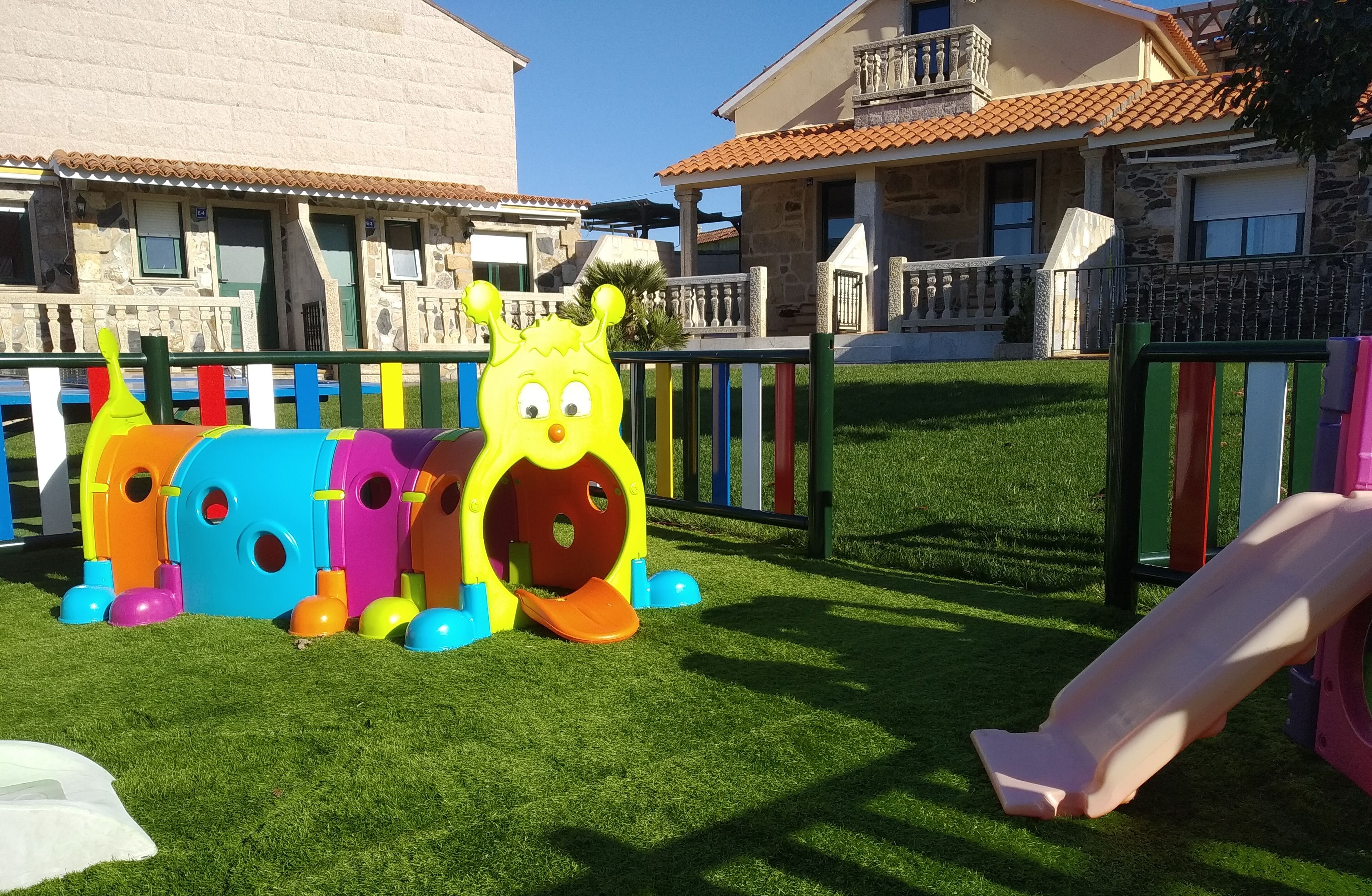 A children's play area with a slide and colorful play structures.