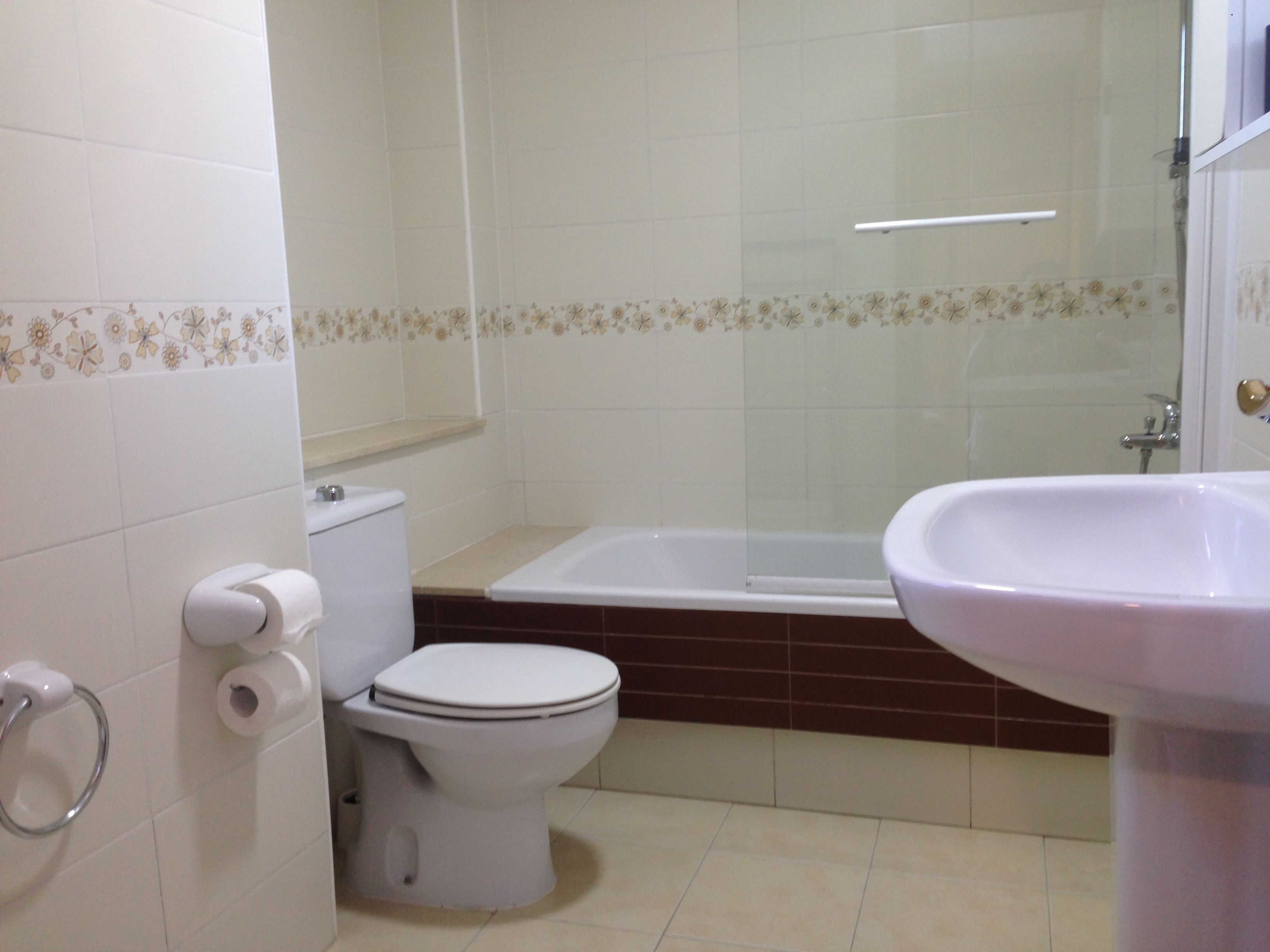 A bathroom with a toilet, a bathtub, and a sink.