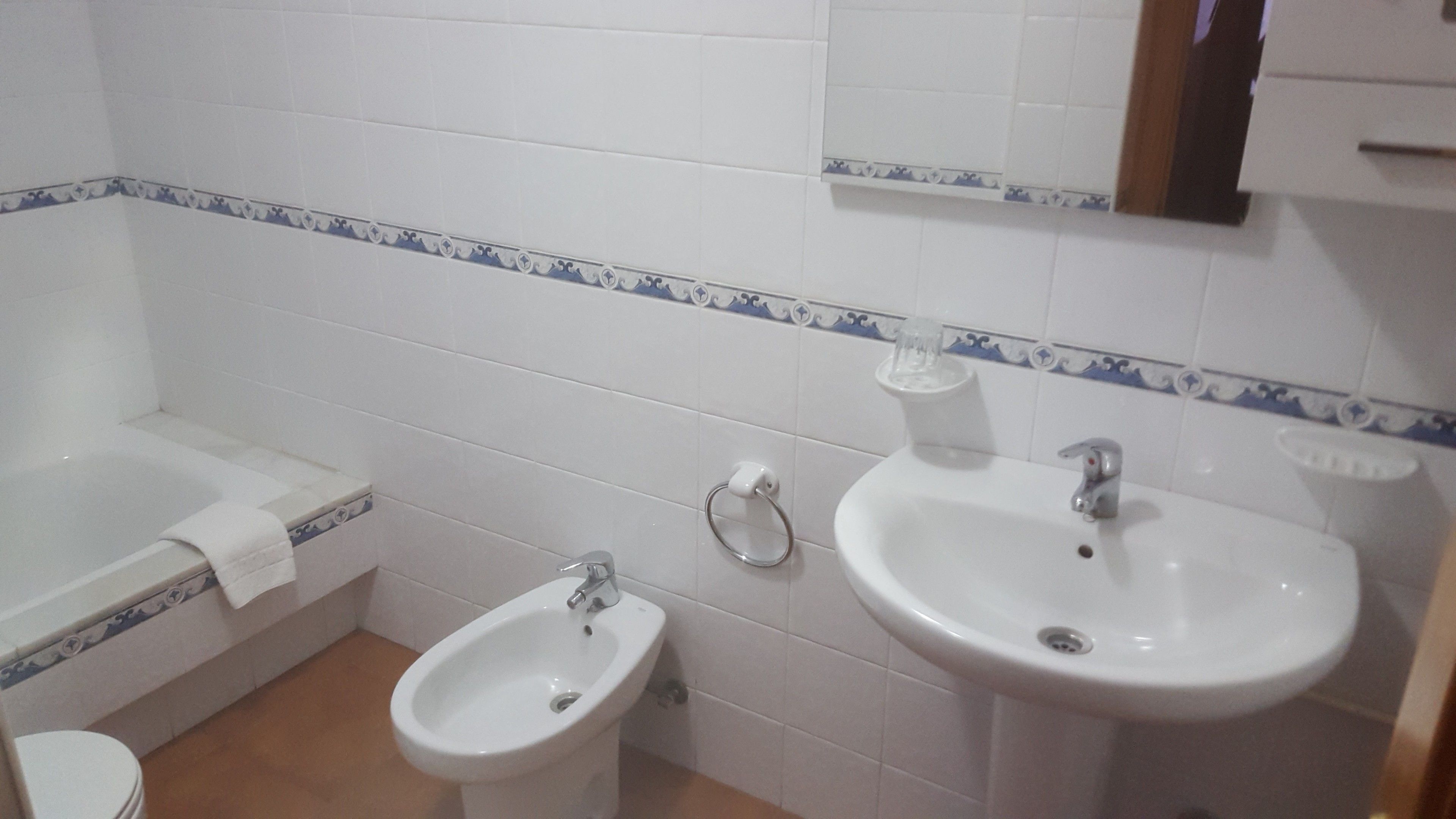 A bathroom with a bathtub, a bidet, and a sink.
