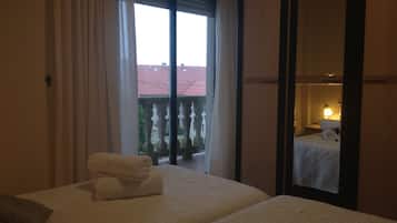 Appartamento familiare, 2 camere da letto, vista mare parziale | 1 camera, copriletto in piuma, postazione laptop, tende oscuranti