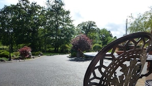 Une chaise en métal ornée de motifs complexes découpés, placée sur une zone pavée bordée de briques.