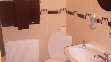 A bathroom with a toilet, sink, and towel rack.
