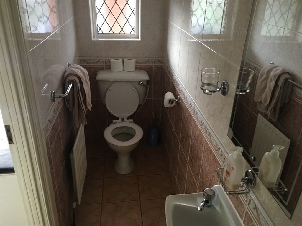 Une petite salle de bain comprenant des toilettes, un lavabo et un miroir.