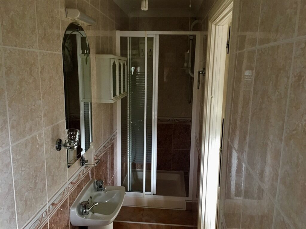 Un baño con lavamanos, espejo y ducha.