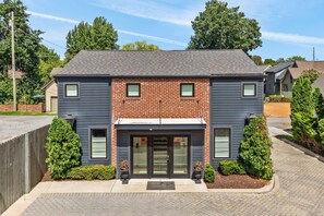 A two-story residential building with a brick facade, a front entrance with glass doors, and a driveway leading to the entrance. - Germantown Inn (Nashville)