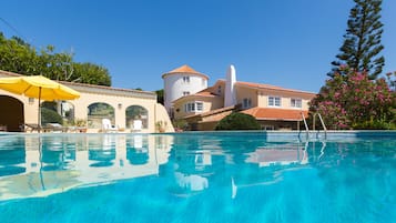 Piscine extérieure, parasols de plage, chaises longues