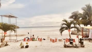 En la playa, arena blanca, sillas reclinables de playa, sombrillas