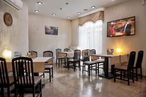 Enjoy meals in this cozy space with a central table, comfortable chairs, and a mounted TV.