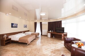Two single beds with matching headboards and a large flat-screen TV are featured in this stylish room.