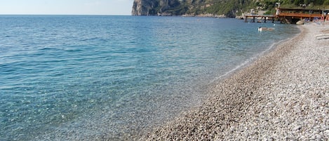 På stranden, solsenger, parasoller og strandbar