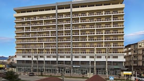 A multi-story hotel with balconies, a visible entrance, and signage for a restaurant. - SunMarInn Resort (Anapa)