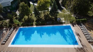 A rectangular pool with a clear blue water surface, surrounded by a wooden deck. - SunMarInn Resort (Anapa)