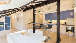 Une cuisine moderne dotée d’un îlot central, de tabourets de bar et d’une table à manger avec des chaises.