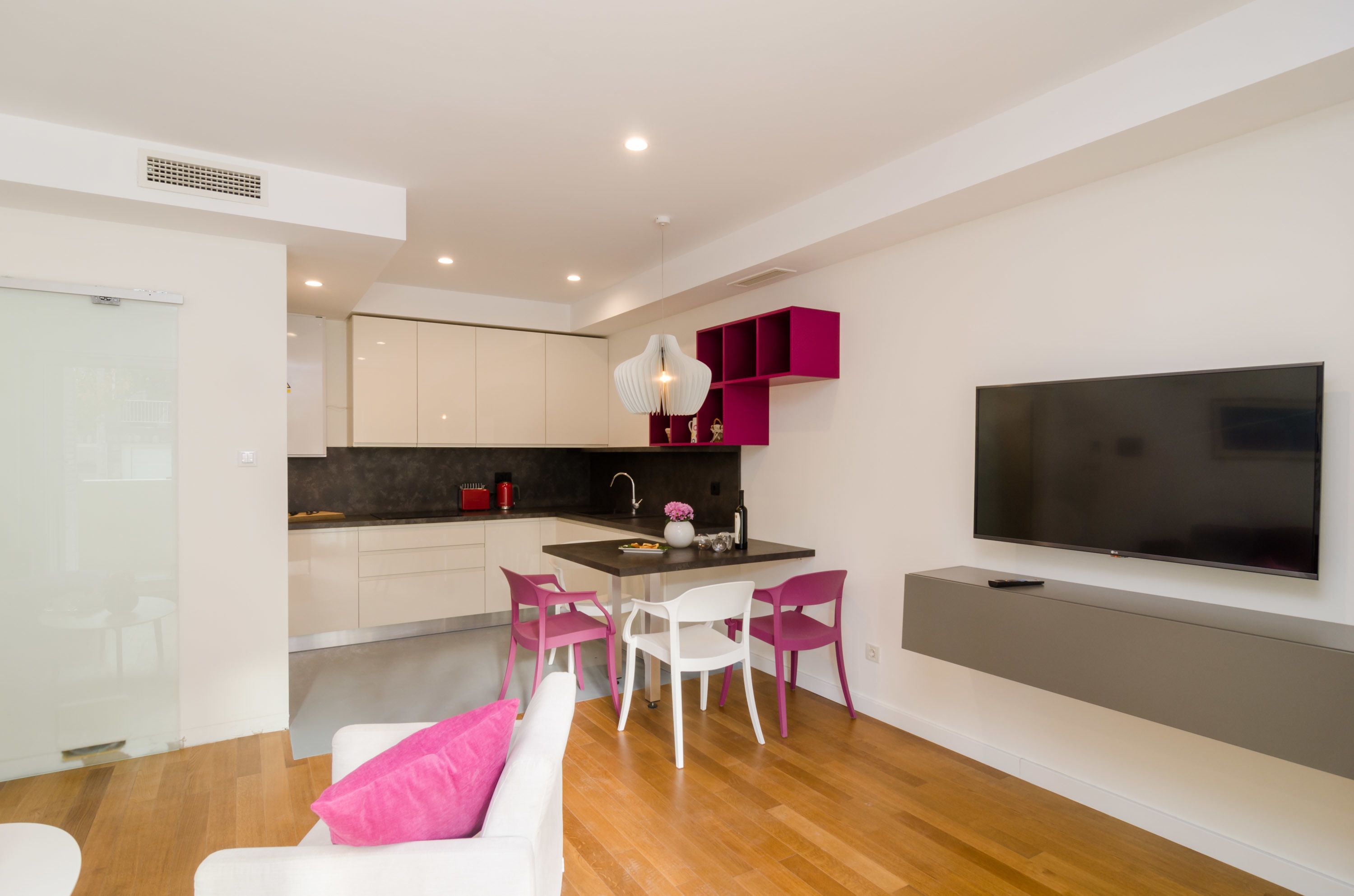 A modern apartment with a kitchen, dining area, and living room.