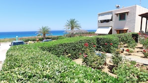Une propriété située sur la côte, dotée d’un jardin, offrant une vue sur la mer et comprenant un bâtiment avec un balcon.