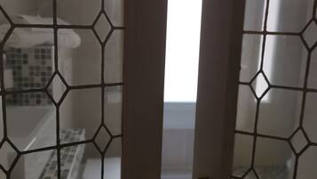 A bathroom with a tiled floor, a white sink, and a mirror.