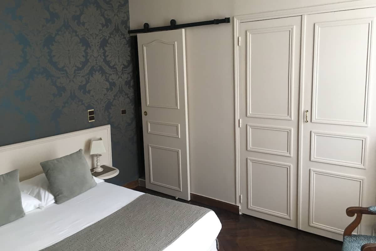 A bedroom with a bed, bedside table, and a wardrobe.