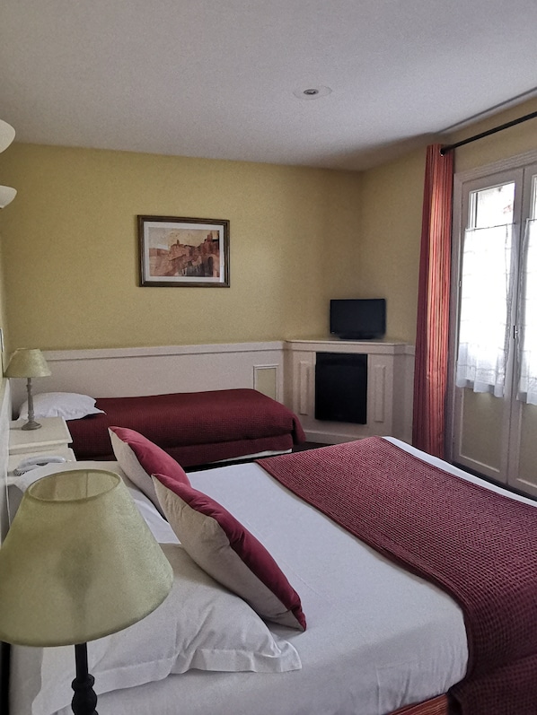 A hotel room with two beds, a television, a painting on the wall, and a window with curtains. - Hotel du Parc - Montpellier (Montpellier)