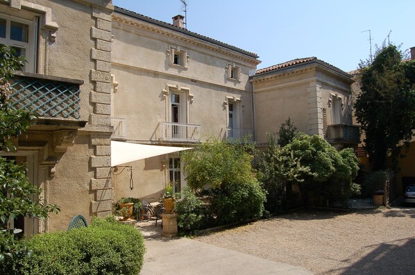 A traditional building with a balcony, a gravel driveway, and surrounding greenery. - Hotel du Parc - Montpellier (Montpellier)