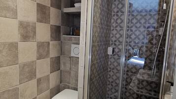 Ein Badezimmer mit Dusche, Toilette und Waschbecken.