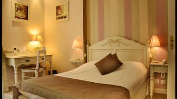A bedroom with a bed, bedside tables, a desk, and chairs.