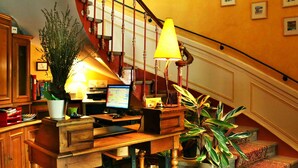 A cozy living area with a wooden desk, computer, and a staircase with a red railing. - Hotel du Parc - Montpellier (Montpellier)