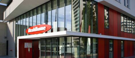 A modern building with a glass facade and a red and white color scheme.