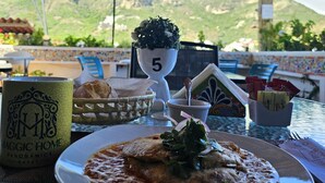 Una mesa de comedor con un plato de comida, una taza y un objeto decorativo con el número 5.