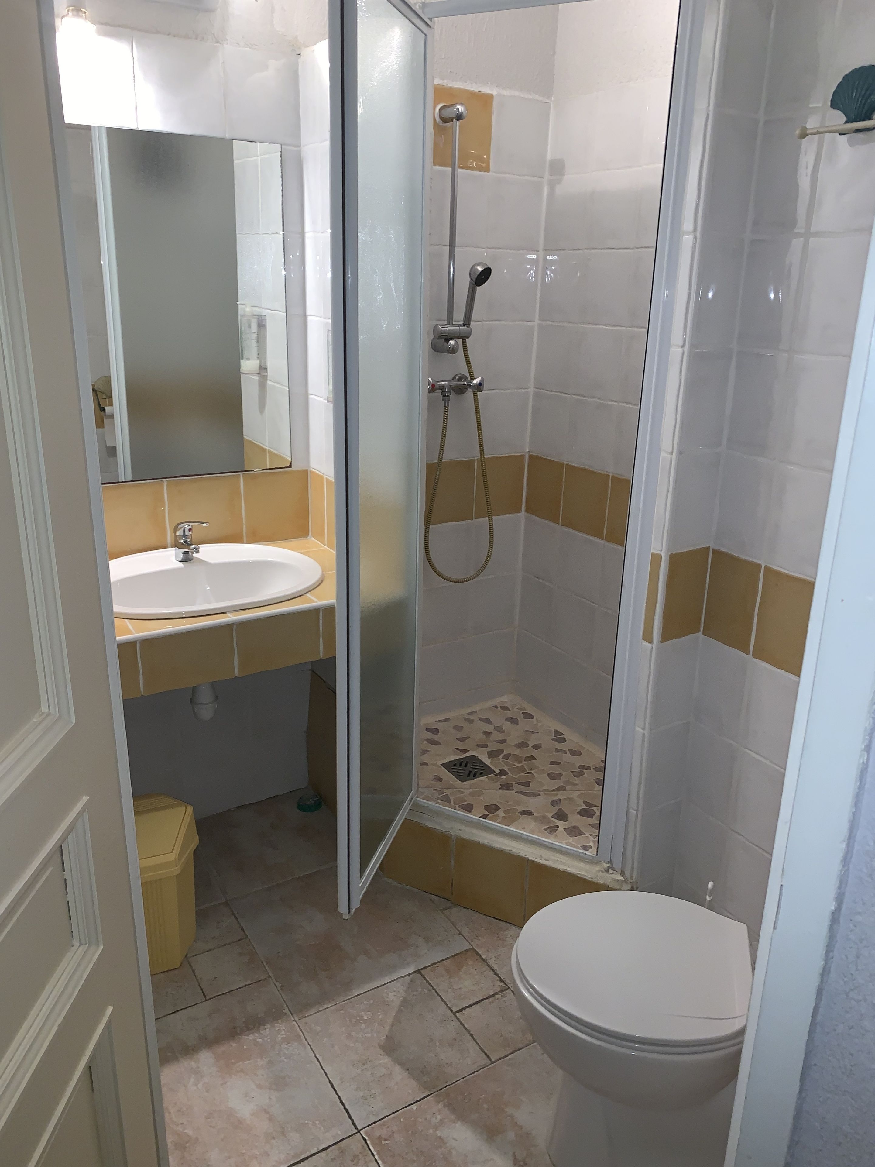 A bathroom with a toilet, sink, and shower.