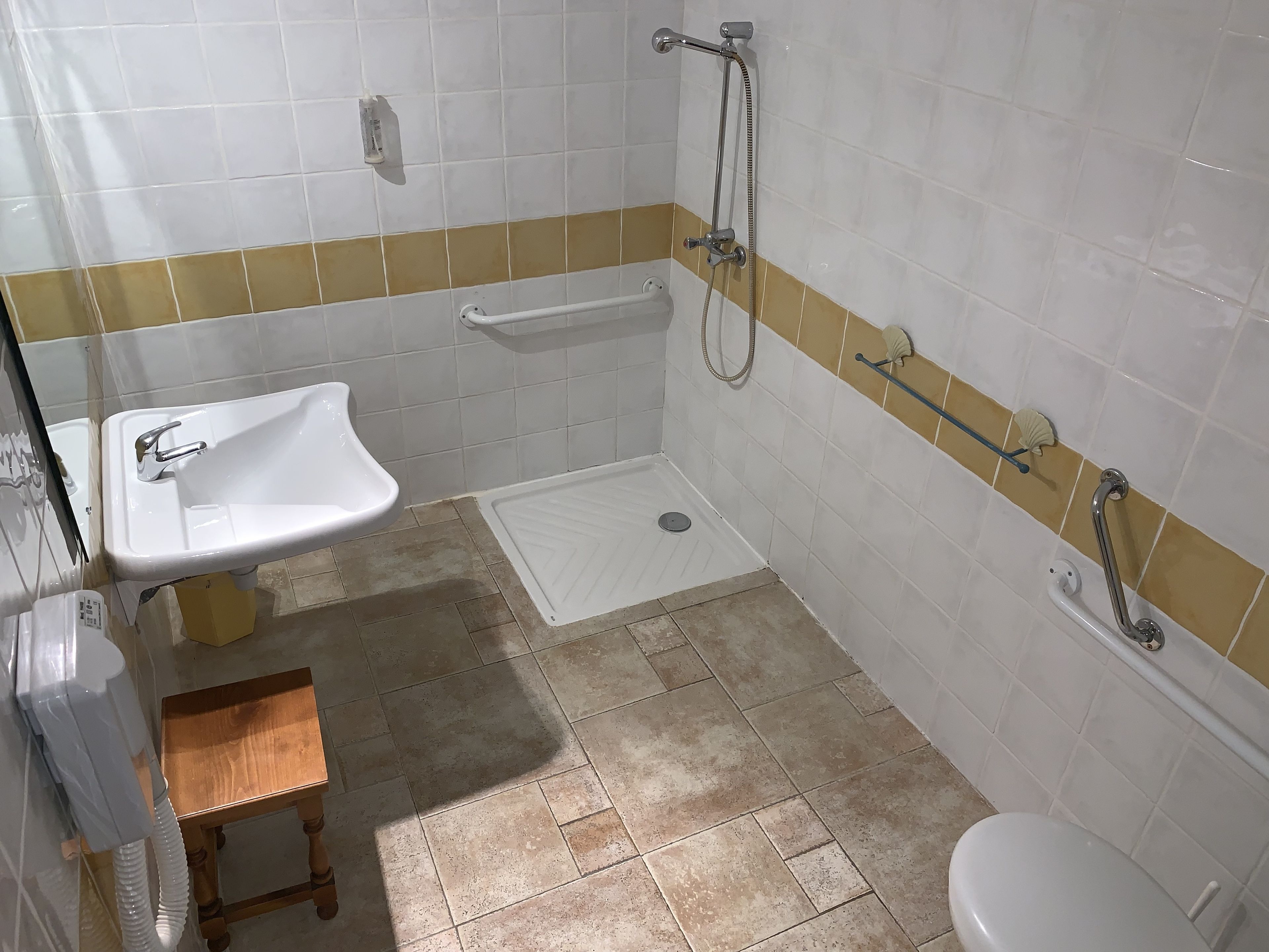 A bathroom with a white sink, a shower, and a toilet.