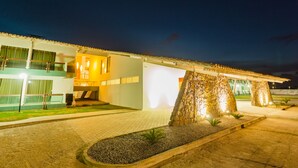 Un edificio moderno con techo plano, ventanas grandes y fachada de piedra.