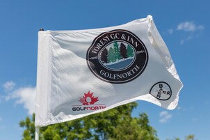Eine Flagge mit den Logos von Forest GC & Inn Golf North und Bayer.