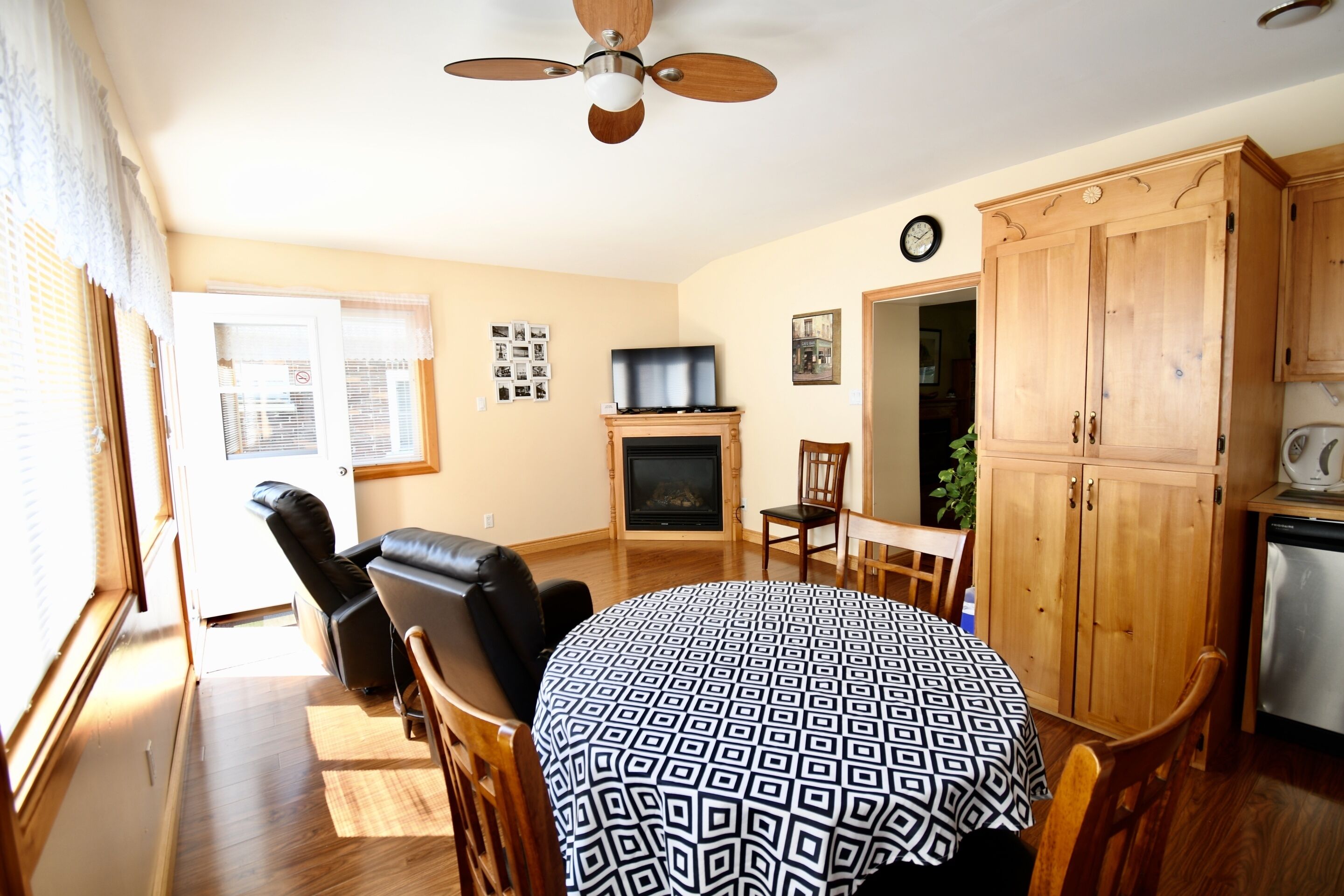 Una sala de estar con chimenea, una mesa de comedor y una zona de cocina.