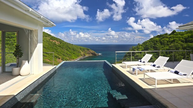A poolside area with lounge chairs and a view of the ocean. - Xhale Luxury Villa (Gros Islet)