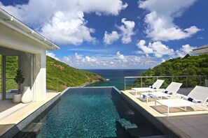 A poolside area with lounge chairs and a view of the ocean. - Xhale Luxury Villa (Gros Islet)