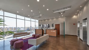 A spacious lobby with a reception desk, seating area, and large windows offering a city view. - City Express by Marriott Ciudad De México La Raza (Mexico City)