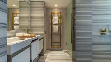 Un baño moderno con un espejo grande, un tocador con lavabo y un perchero para toallas.