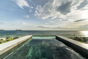 A rooftop infinity pool with a clear view of the ocean and distant islands. - Lifestyle Laghetto Collection (Rio de Janeiro)
