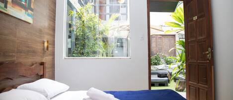 Een slaapkamer met een bed, een raam en uitzicht.