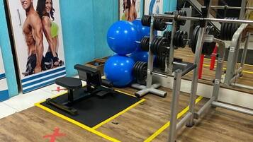 A gym with exercise equipment, including dumbbells and a bench.