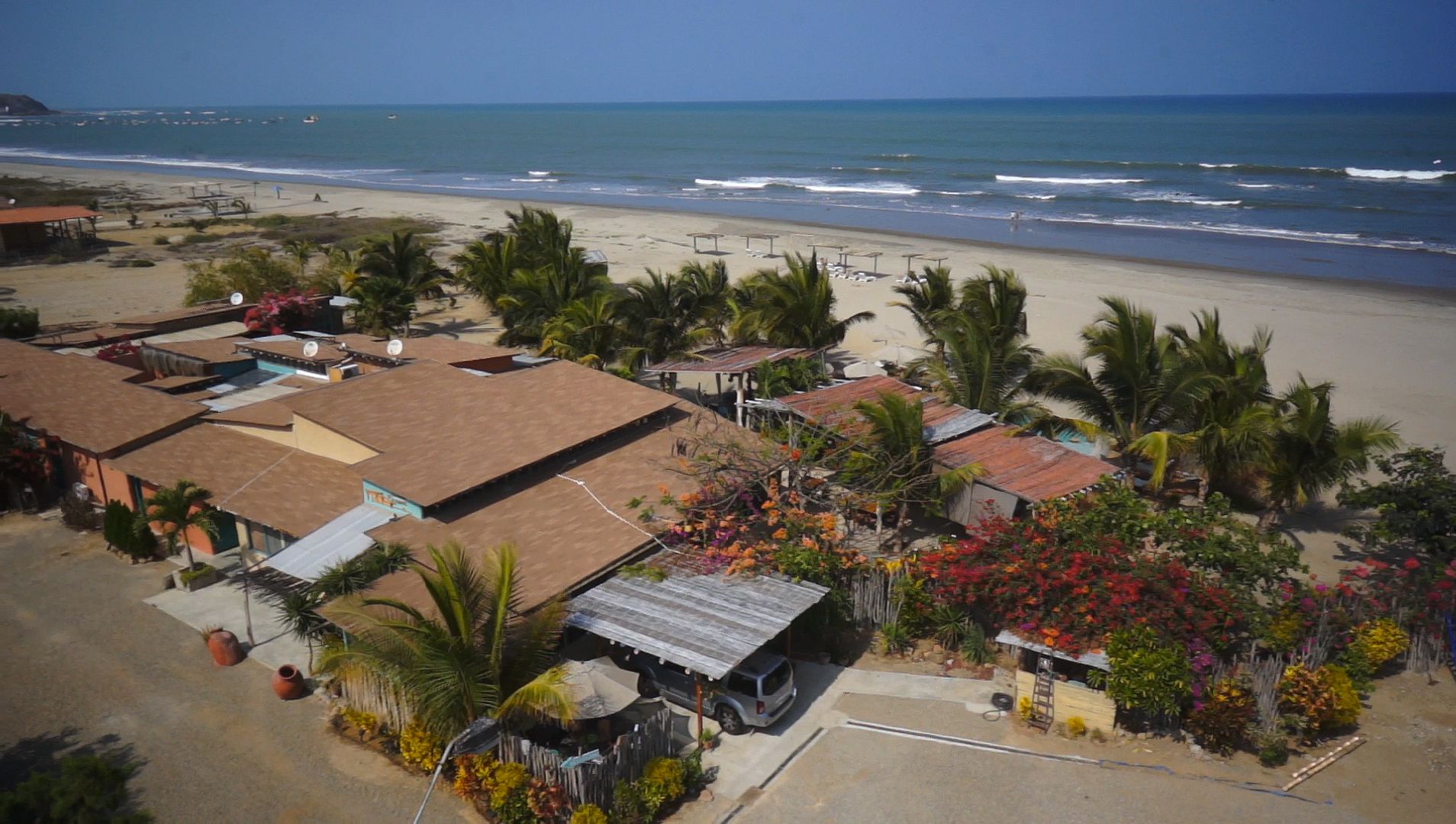 Propiedad costera con varias edificaciones, playa y vistas al océano.