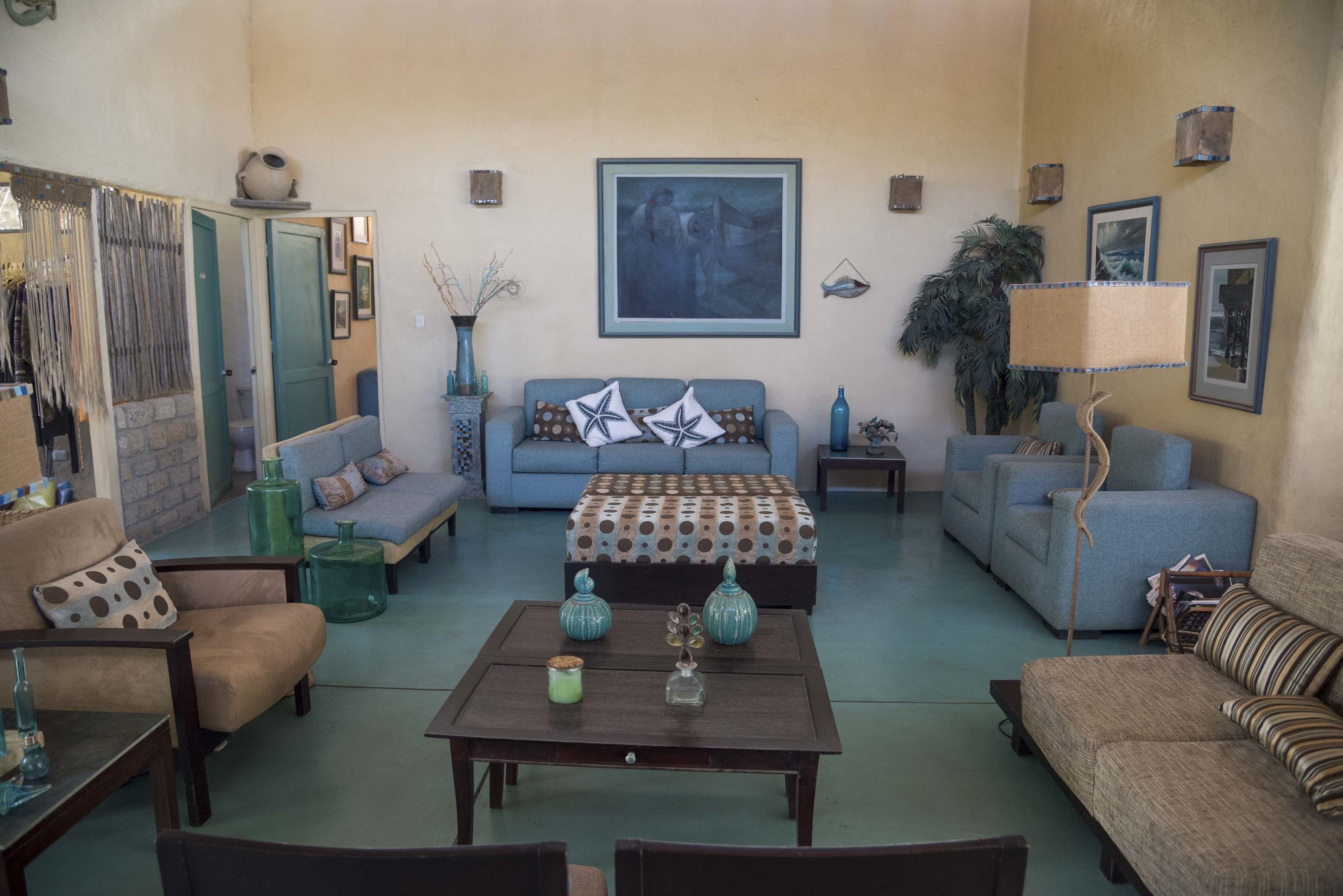 A living room with a sofa, armchairs, a coffee table, and a lamp.