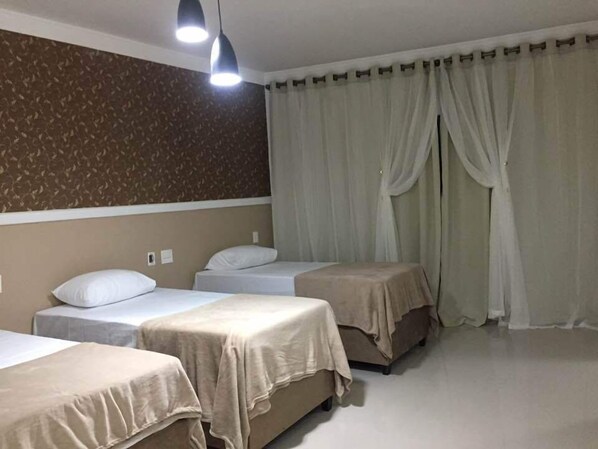 Habitación triple | Baño | Ducha, artículos de higiene personal gratuitos, albornoces y toallas