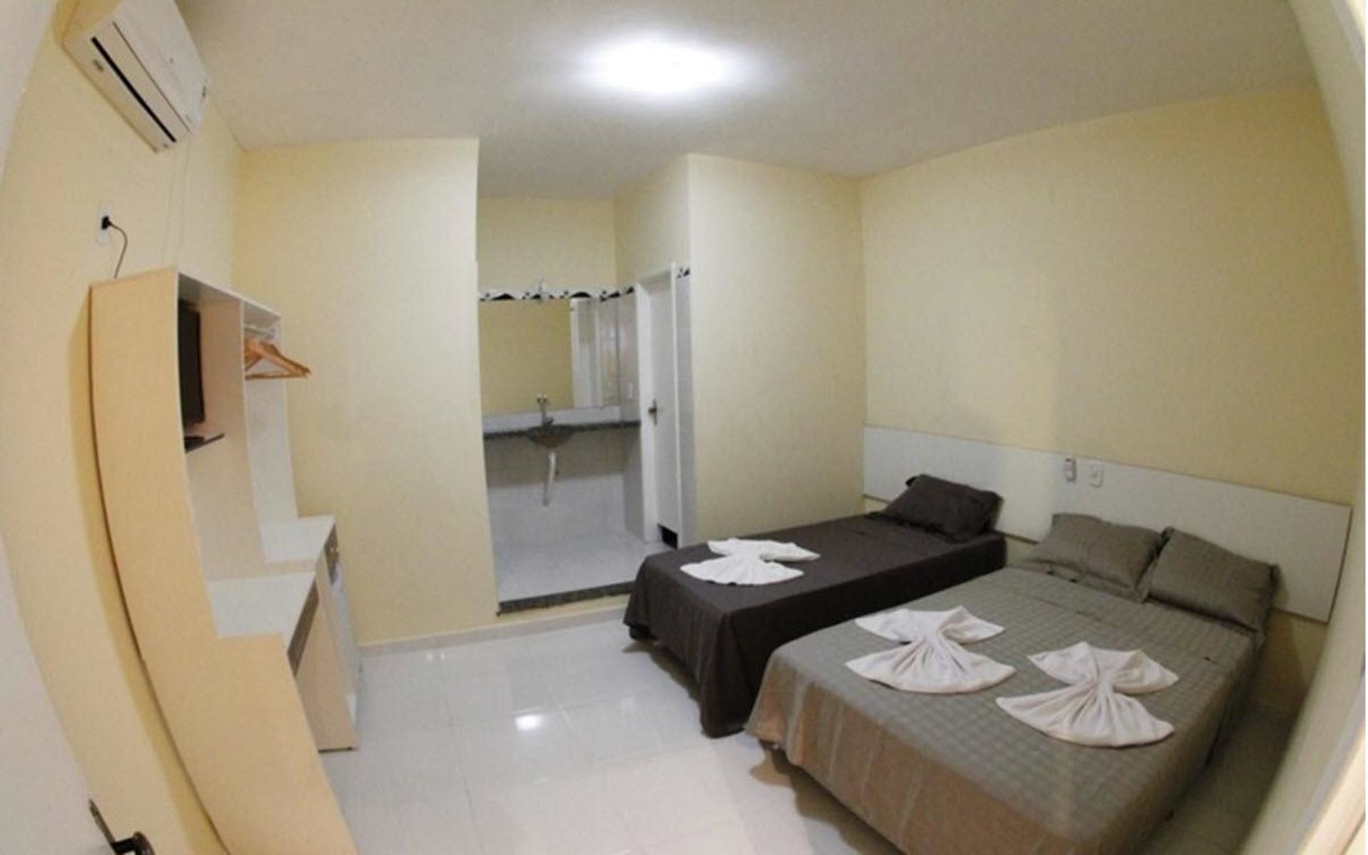 Habitación de hotel con dos camas, baño y armario.