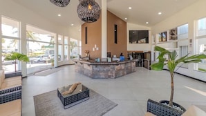 A spacious lobby with a reception desk, large windows, and modern pendant lighting.