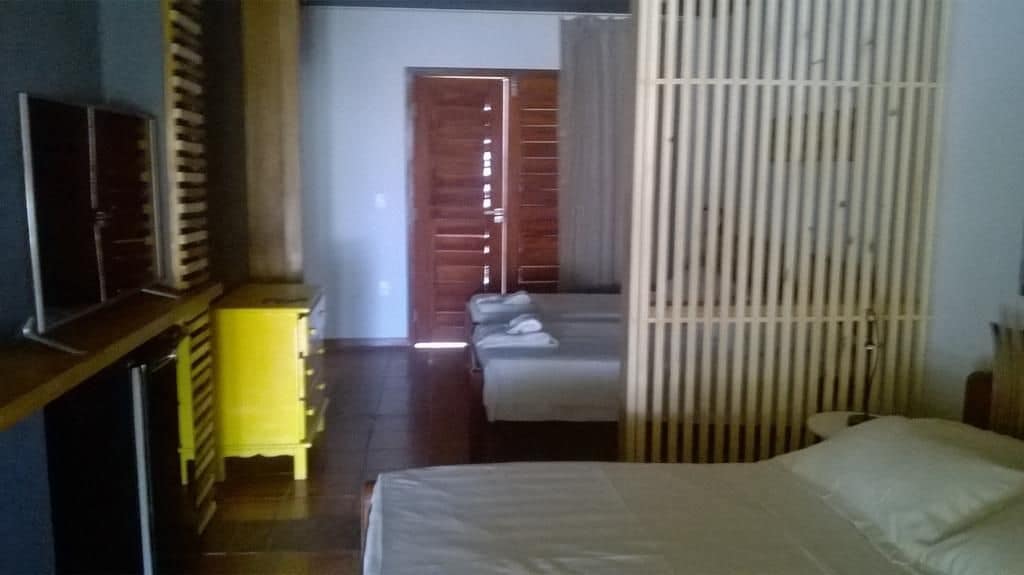 A bedroom with a bed, a wardrobe, and a door leading to another room.